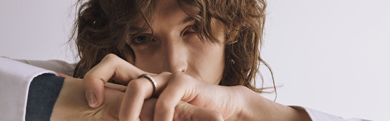 Stylish young man with curly hair showcasing a confident yet contemplative expression