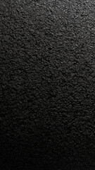 Fototapeta premium Shiny asphalt surface with irregular texture, captured in dark lighting for gritty, industrial-style phone wallpapers.