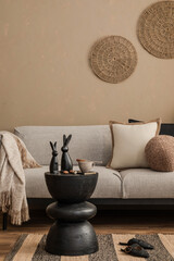 Cozy beige living room with black decor bunnies and rustic coffee table styled for spring.