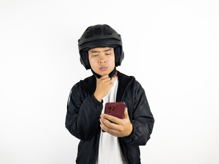 Asian man wearing helmet holding mobile phone showing thinking about something gesture isolated on white background