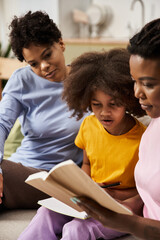 Loving family moment as two mothers read with their daughter on a cozy afternoon