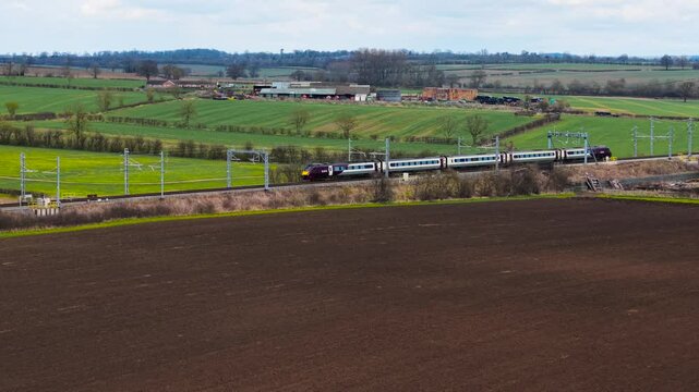 Two passenger trains speeding in opposite directions. Fast-moving trains crossing each other on parallel tracks. Two electric locomotives traveling at high speed in different directions. Passenger