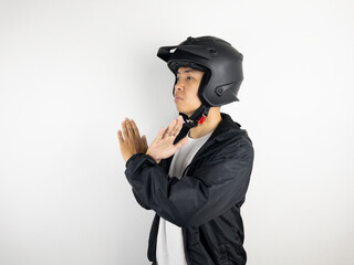 asian man wearing motorcycle helmet with open hand doing stop sign with serious and confident expression, defense gesture isolated on white background