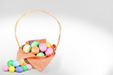 Colored Easter eggs in basket on a background.