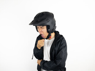 Asian man wearing motorcycle helmet coughing on white background