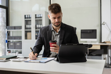 Businessman male working at office with laptop and documents on desk, financial adviser analyzing data.