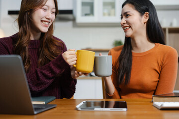 Fototapeta premium Lifestyle people, Happy two woman enjoys breakfast sitting in the kitchen.