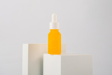 Plastic yellow tube for cream or lotion. Skin care or sunscreen cosmetic with stylish props on white background.