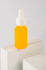 Plastic yellow tube for cream or lotion. Skin care or sunscreen cosmetic with stylish props on white background.