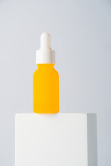 Plastic yellow tube for cream or lotion. Skin care or sunscreen cosmetic with stylish props on white background.