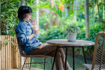 Portrait image of a beautiful young asian woman holding and drinking iced fruit juice frappe.