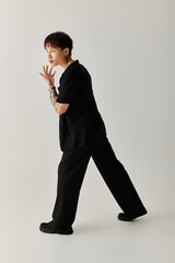 Obraz premium Stylish young Asian man striking a pose in a modern studio setting