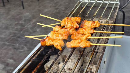 Juicy marinated pork skewers being grilled over hot charcoal, perfect for outdoor barbecue or street food preparation