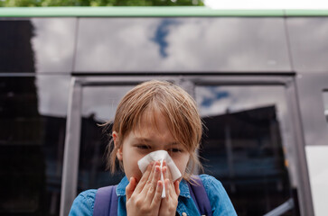 Young boy with a runny nose, holding a tissue. Symptoms of cold, flu, or allergies. Child...