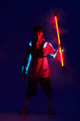 Young stylish Asian man showcasing vibrant lighting in dynamic urban environment
