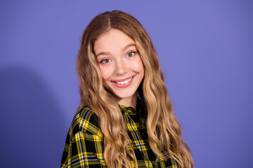Fototapeta premium Smiling young woman in checkered shirt against purple background, conveying positive and stylish vibe