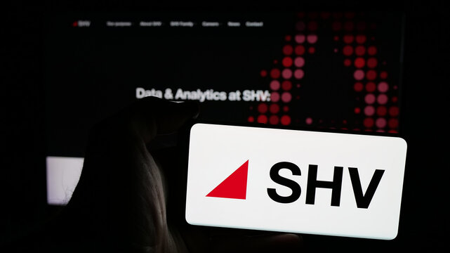 Stuttgart, Germany - 03-06-2025: Person holding mobile phone with logo of Dutch trading company SHV Holdings N.V. on screen in front of business web page. Focus on phone display.