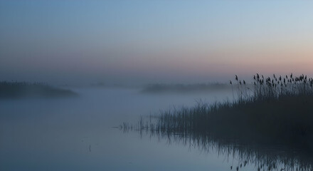 Fototapeta premium Misty Sunrise Over a Calm Lake