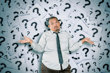 Confused Businessman Shrugging with Question Marks in Background