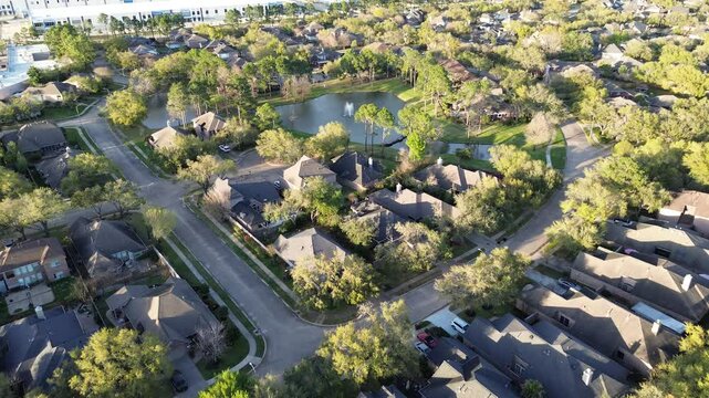 Spinning water fountain in lakeside gated community upscale green residential neighborhood near business park warehouse fulfillment center in northwestern Harris County, Houston, Texas, flyover