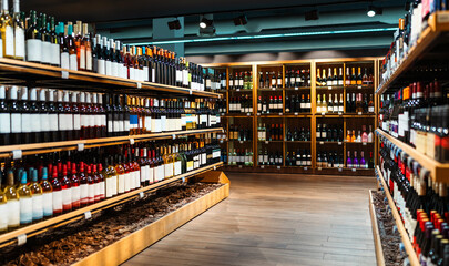 Liquor store background. Wine bottles on shelves in wine shop.
