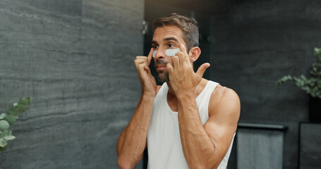 Beauty, dermatology and eye mask with man in bathroom of home for antiaging cosmetics or wellness....