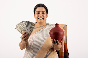 Indian woman presenting indian rupees. woman wearing traditional saree while isolated white...
