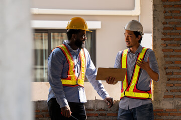 Construction engineers supervising progress of construction project. engineering or worker in safety vest observing a building A team of construction engineers. workers at the construction site.