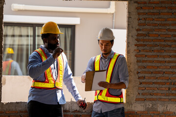 Construction engineers supervising progress of construction project. engineering or worker in safety vest observing a building A team of construction engineers. workers at the construction site.