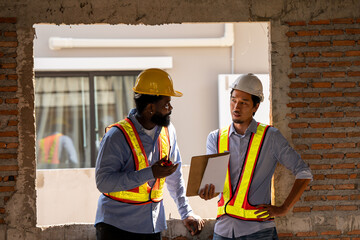 Construction engineers supervising progress of construction project. engineering or worker in safety vest observing a building. worker, Architecture, engineer, architect wearing safety helmet meeting.