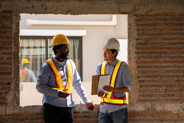 Construction engineers supervising progress of construction project. engineering or worker in safety vest observing a building. worker, Architecture, engineer, architect wearing safety helmet meeting.