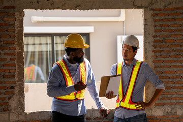 Construction engineers supervising progress of construction project. engineering or worker in safety vest observing a building. worker, Architecture, engineer, architect wearing safety helmet meeting.