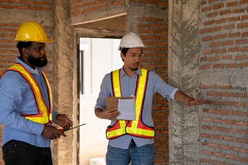 Construction engineers supervising progress of construction project. engineering or worker in safety vest observing a building A team of construction engineers. workers at the construction site.
