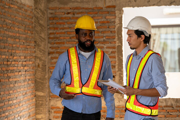 Construction engineers supervising progress of construction project. engineering or worker in safety vest observing a building A team of construction engineers. workers at the construction site.