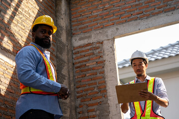 Construction engineers supervising progress of construction project. engineering or worker in safety vest observing a building. worker, Architecture, engineer, architect wearing safety helmet meeting.