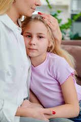 Mother comforting daughter in cozy living room  