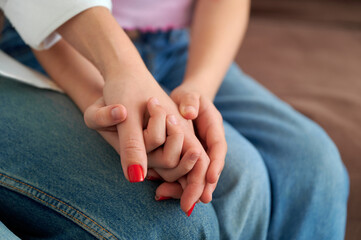 Hands Holding Together in a Moment of Connection on a Couch  
