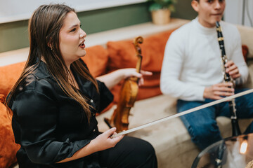 An indoor scene with two musicians, a woman holding a violin and a man playing a clarinet, seated together on a comfortable couch in a cozy setting.