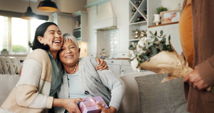 Birthday, gift or laughing with family on sofa in living room of home together for bonding or celebration. Box, funny or hugging with senior woman and daughter in apartment for event or milestone