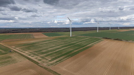 Des éoliennes  vues en hauteur avec un drone, le ciel est très nuageux et gris, avec quelques...