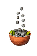 Blueberries in a ceramic bowl isolated on white background. Dark blue, ripe, raw berries with mint leaves
