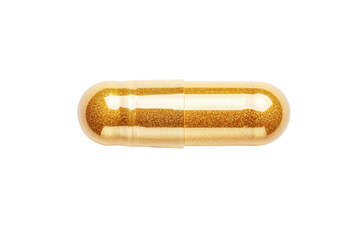 Shiny gold capsule pill isolated on black background in close-up view, cut out