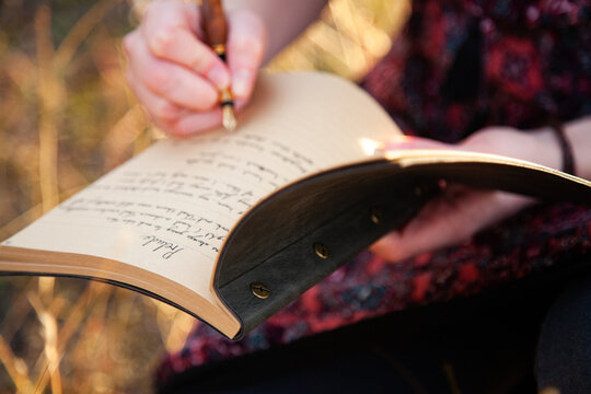 Writer holding fountain pen and notebook for writing in