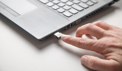  Male hand connecting usb stick to laptop.