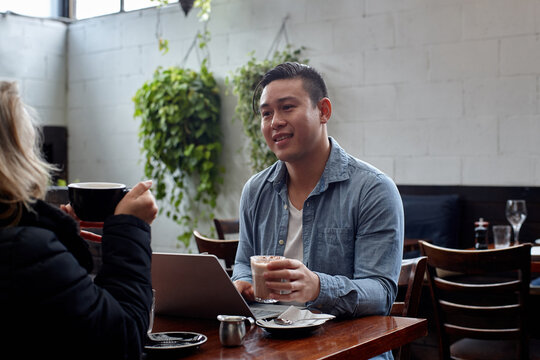 Man sitting at table at restaurant talking with friend