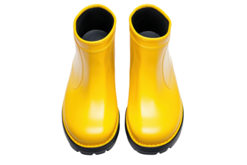 Pair of shiny yellow rubber boots with black soles, cut out