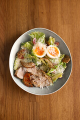 Classic Caesar salad with eggs, chicken, cheese, green lettuce, sprinkled with cheese
