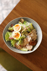 Classic Caesar salad with eggs, chicken, cheese, green lettuce, sprinkled with cheese