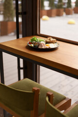 Breakfast, plate with scrambled eggs, toast, chicken breast, cheese, tomatoes, lettuce and sauce