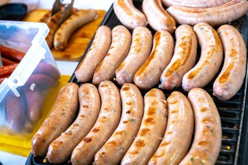 Delicious grilled pork sausages rollin on hot grill pan